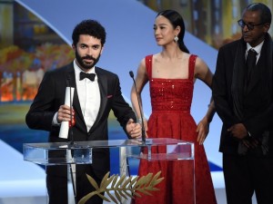 O diretor libanês Ely Dagher discursa ao lado da atriz chinesa Zhou Yun e o diretor mauritano Abderrahmane Sissako, depois de receber o prêmio de curta-metragem 